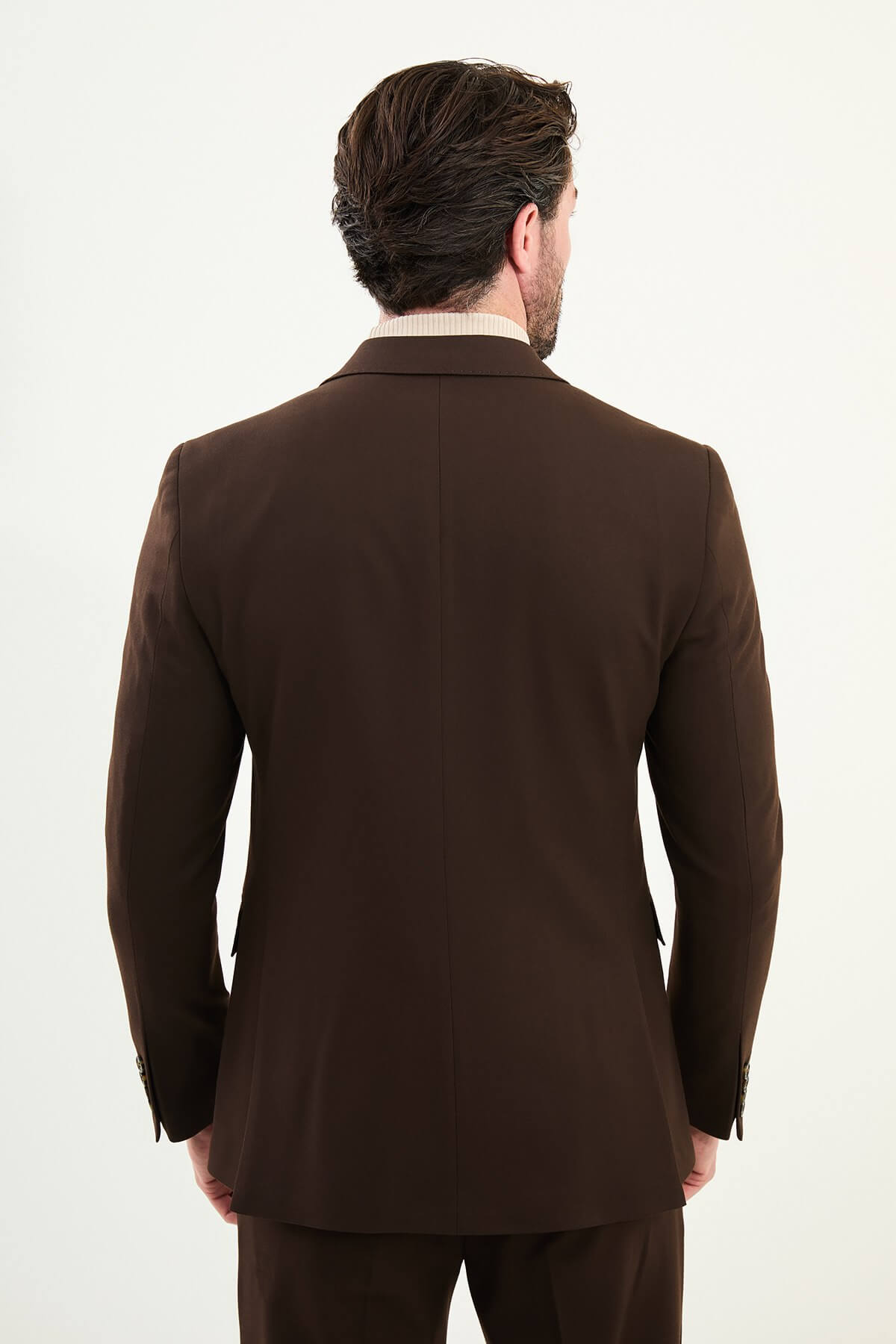 Men wearing chocolate brown slim-fit double-breasted wool-blend suit with peak lapels and cream turtleneck, winter formal outfit.