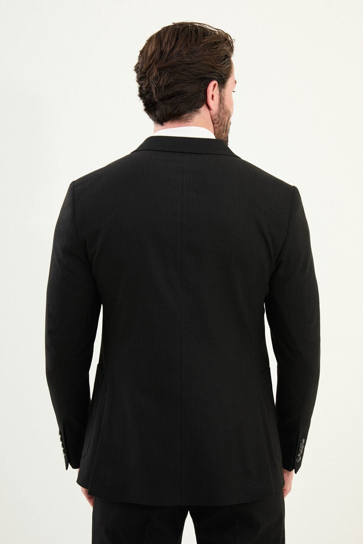 Men’s black mono-collar slim-fit suit with band/mandarin neckline, matte finish tailoring, single-breasted jacket styled with a white turtleneck, travel-ready stretch wool-viscose blend.