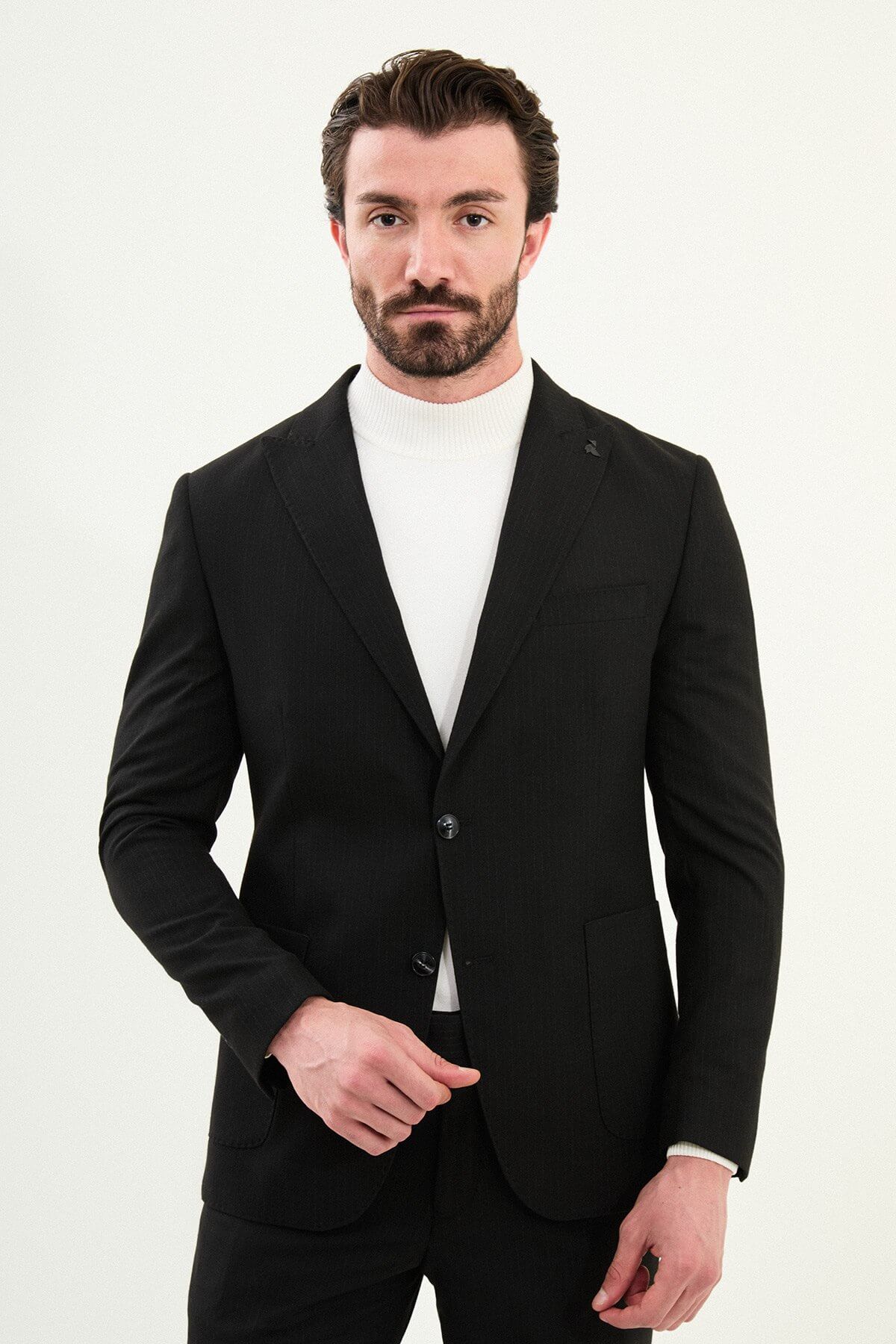 Men’s black mono-collar slim-fit suit with band/mandarin neckline, matte finish tailoring, single-breasted jacket styled with a white turtleneck, travel-ready stretch wool-viscose blend.
