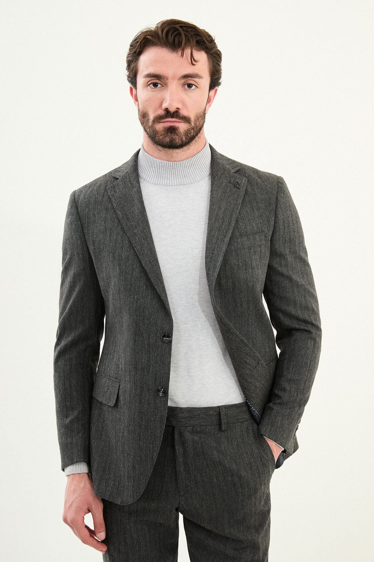 Men’s gray herringbone slim-fit suit with structured shoulders and tailored waist, high-wool blend fabric with stretch for winter wear, styled with a light gray fine-gauge turtleneck