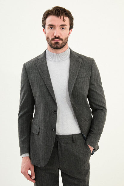Men’s gray herringbone slim-fit suit with structured shoulders and tailored waist, high-wool blend fabric with stretch for winter wear, styled with a light gray fine-gauge turtleneck