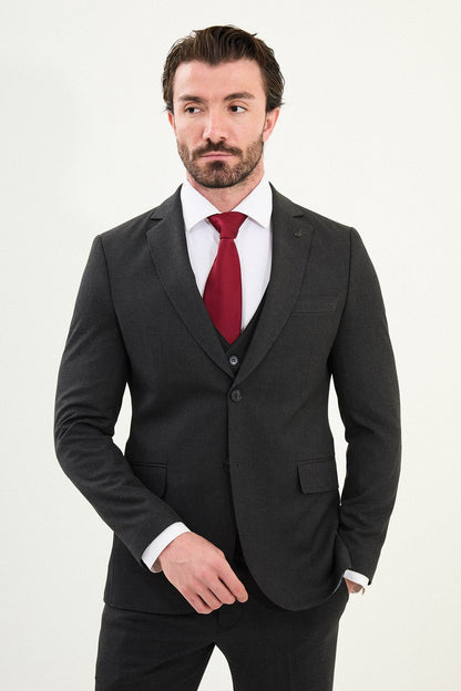 Men’s matte black slim-fit three-piece wool-blend suit with single-breasted jacket, V-neck waistcoat, slim tapered trousers, tonal buttons, and origami lapel pin.