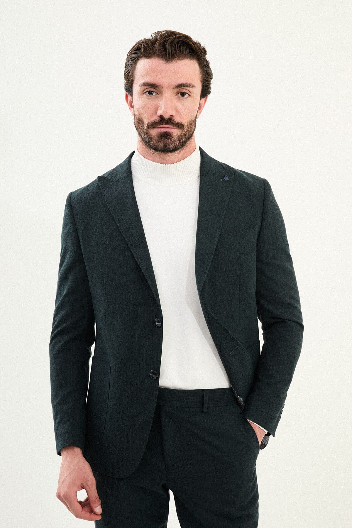 Men’s dark green slim-fit mono-collar (mandarin collar) suit with single-breasted jacket, matte micro-texture fabric, and clean minimalist tailoring designed for turtleneck layering.