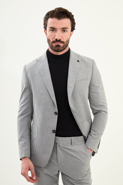 Men’s gray slim-fit mono-collar (mandarin collar) performance suit with 2-button single-breasted jacket, minimalist patch pockets, matte micro-texture fabric, styled with a black turtleneck.