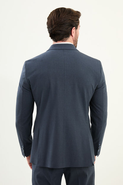 Men’s navy blue slim-fit double-breasted 6x2 suit with peak lapels, matte micro-texture finish, cotton-wool-viscose blend with stretch for wrinkle-resistant wear, styled with a white turtleneck.