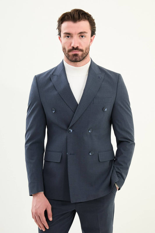 Men’s navy blue slim-fit double-breasted 6x2 suit with peak lapels, matte micro-texture finish, cotton-wool-viscose blend with stretch for wrinkle-resistant wear, styled with a white turtleneck.