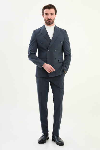 Men’s navy blue slim-fit double-breasted 6x2 suit with peak lapels, matte micro-texture finish, cotton-wool-viscose blend with stretch for wrinkle-resistant wear, styled with a white turtleneck.